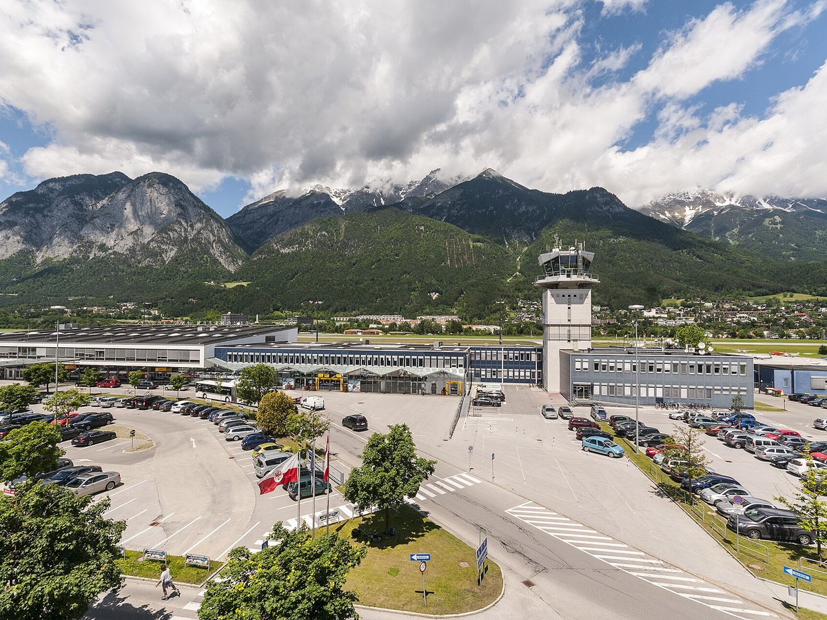 Reisende mit Koffern vor einer Anzeigetafel am Flughafen