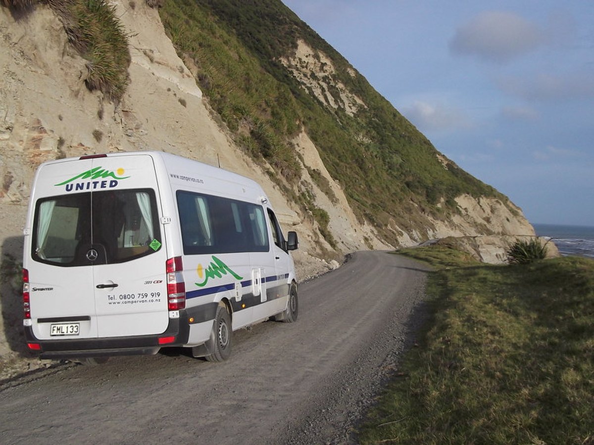 Wohnmobil auf einer Küstenstraße mit Blick aufs Meer