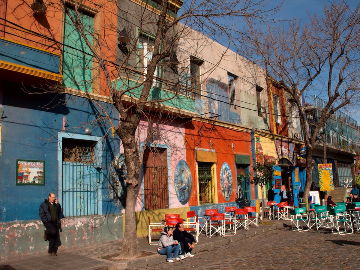 Touristen schlendern durch eine bunte Altstadtgasse in einer europäischen Stadt