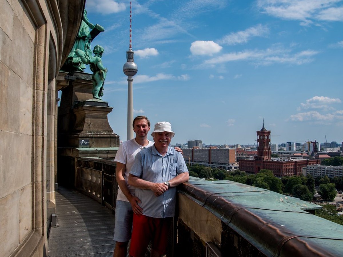 Reisende mit Koffer vor einer europäischen Stadtkulisse