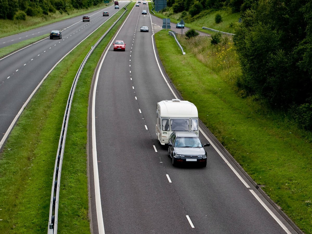 Auto zieht einen Wohnwagen auf einer Landstraße