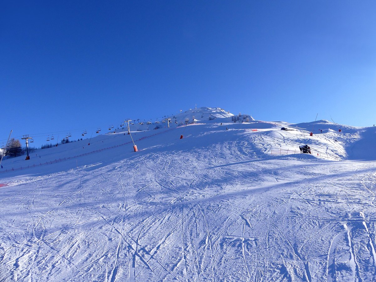 Skipisten in einem Alpengebiet bei Sonnenschein